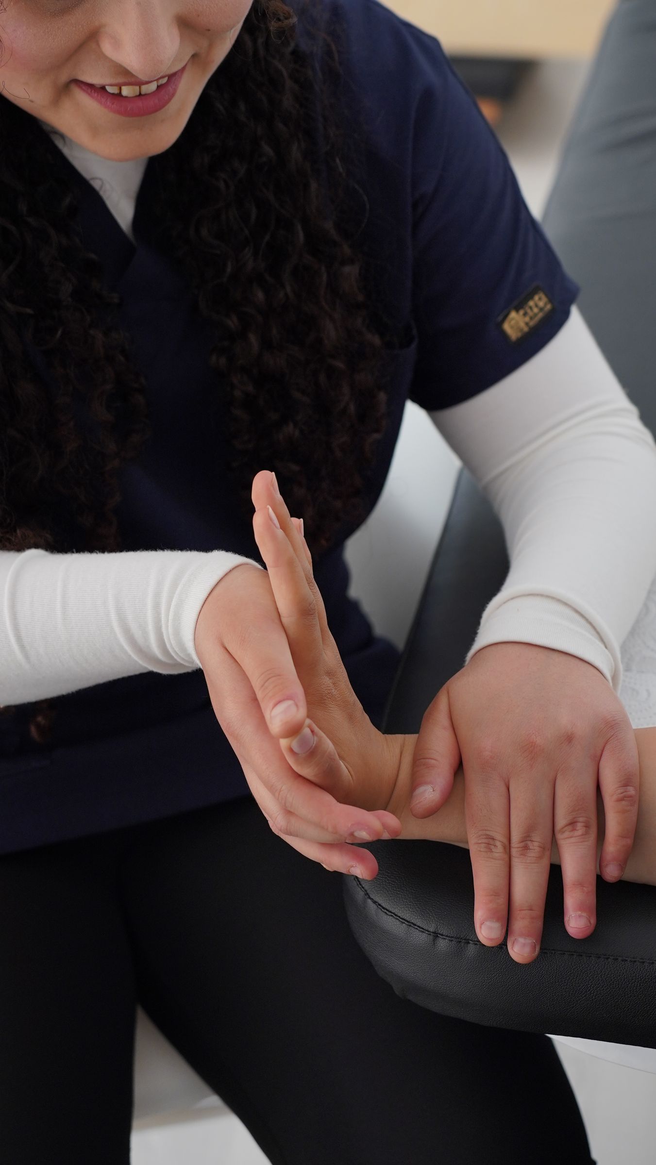 A therapist supporting a patient's wrist during hand therapy