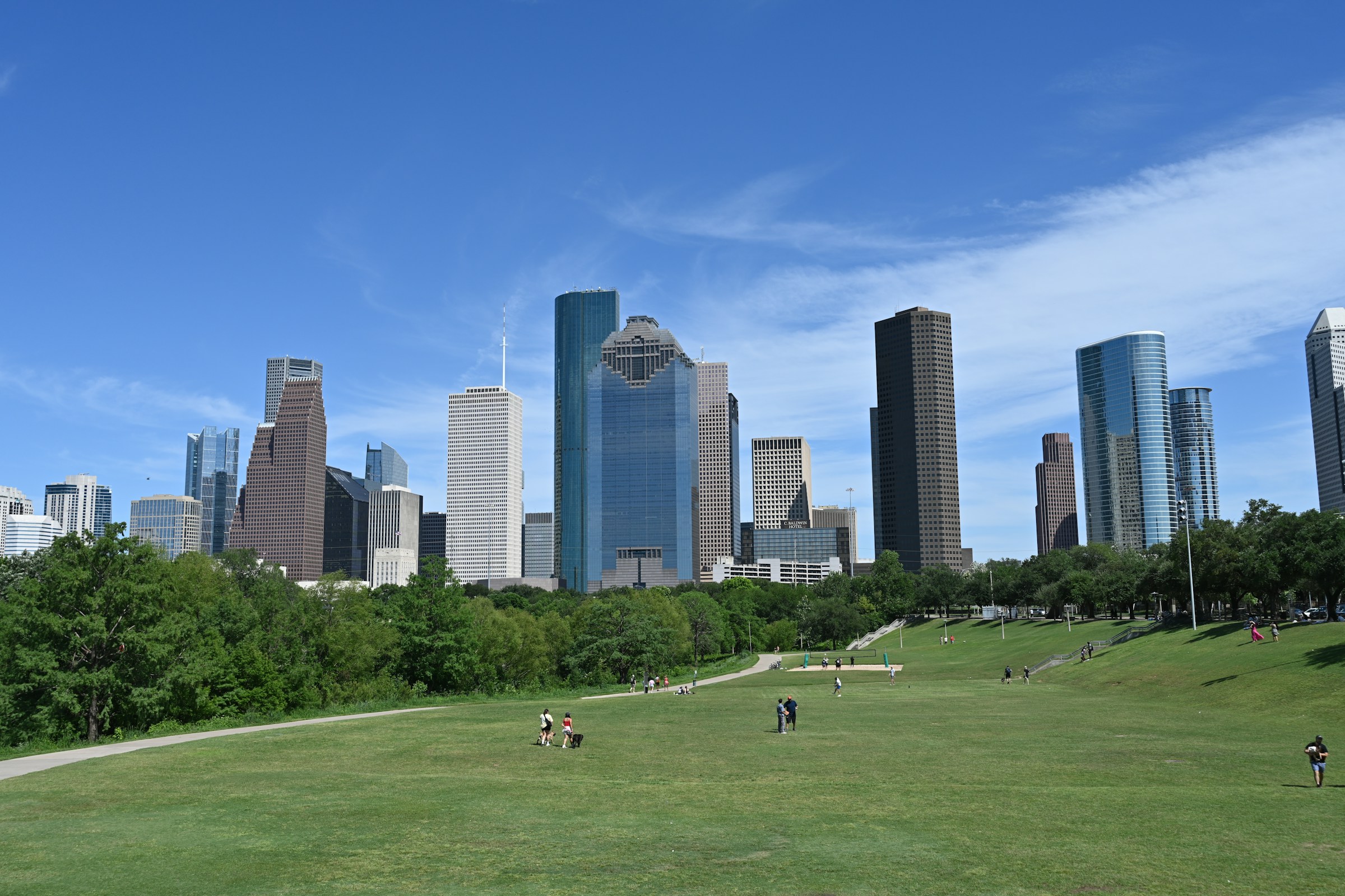 The downtown Houston skyline above a green park on a clear day